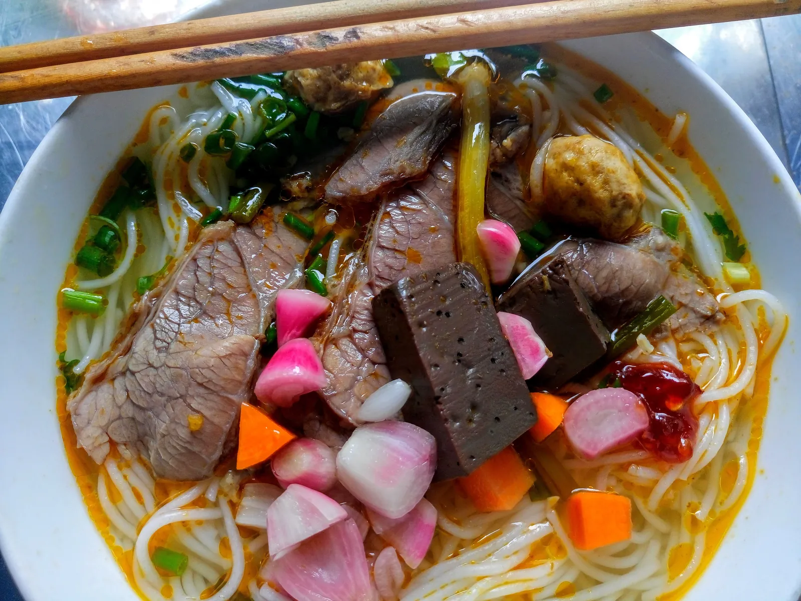 Skål med bun bo Hue med nötkött, blodpudding, citrongräs och risnudlar i kryddig buljong