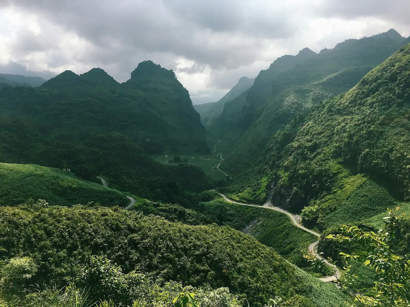 Slingrande bergsväg genom gröna kalkstensberg i norra Vietnam nära kinesiska gränsen
