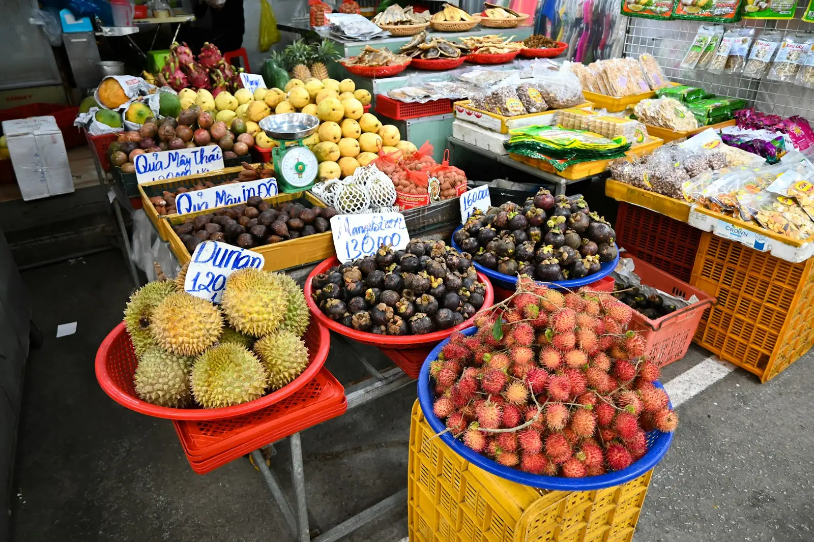 Fruktstånd med durian, mangostan och rambutan och handskrivna priser i dong