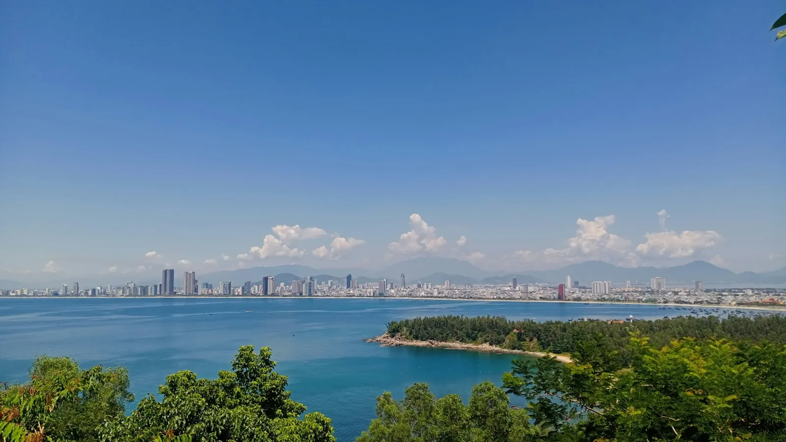 Utsikt från Son Tra-halvöns skogsklädda sluttningar över bukten mot Da Nangs skyline