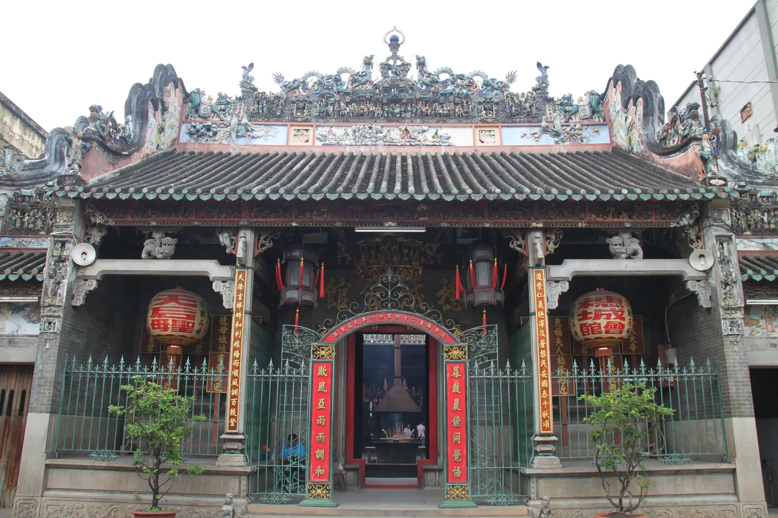 Fasaden på Thien Hau-templet i Cholon med keramikfigurer på taket och röda lyktor