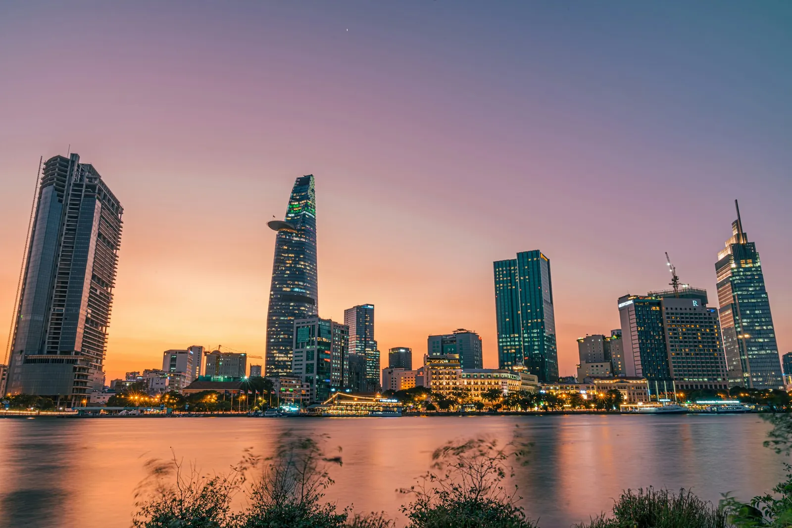 Ho Chi Minh-stadens skyline med Bitexco-tornet vid Saigonfloden i solnedgång