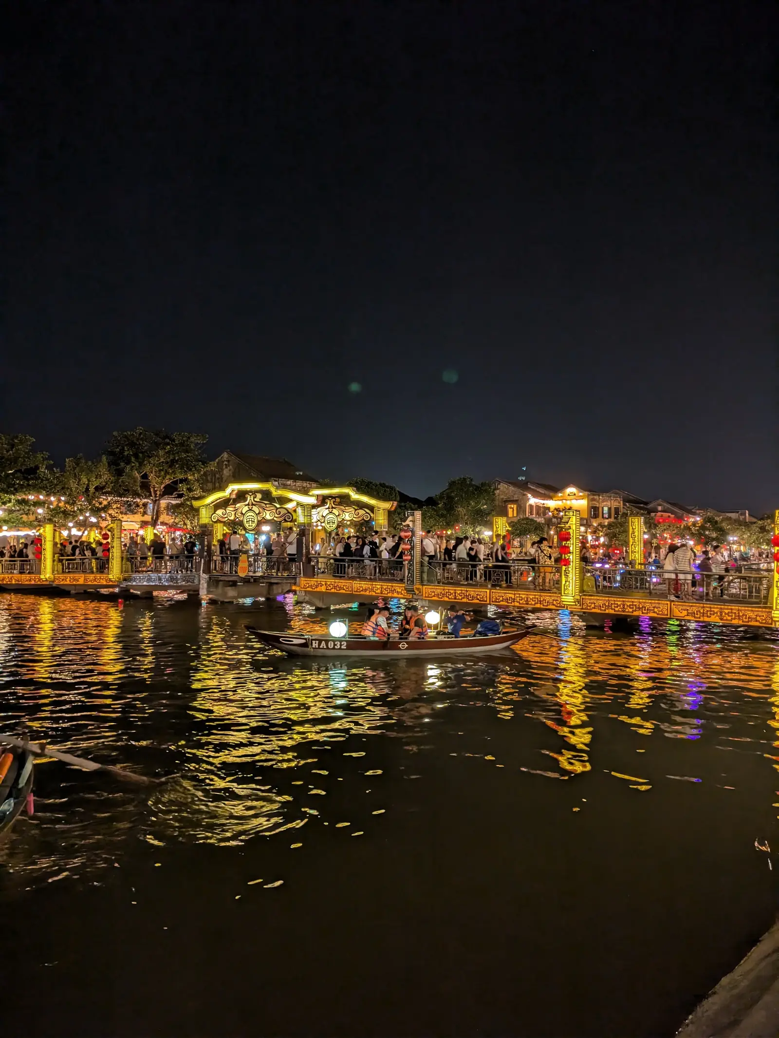 Upplysta båtar och lyktor längs Thu Bon-floden i Hoi An på kvällen