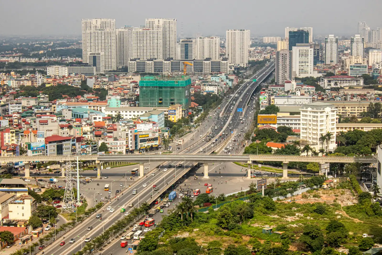 Upphöjd motorväg med trafik genom höghusbebyggelse i Hanoi sedd från ovan