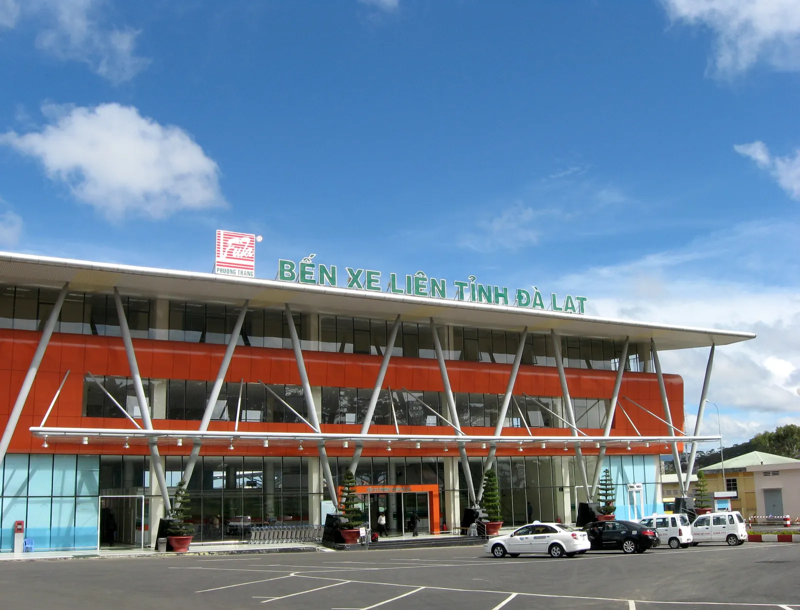 Den orange terminalbyggnaden på Da Lats busstation för fjärrbussar under blå himmel