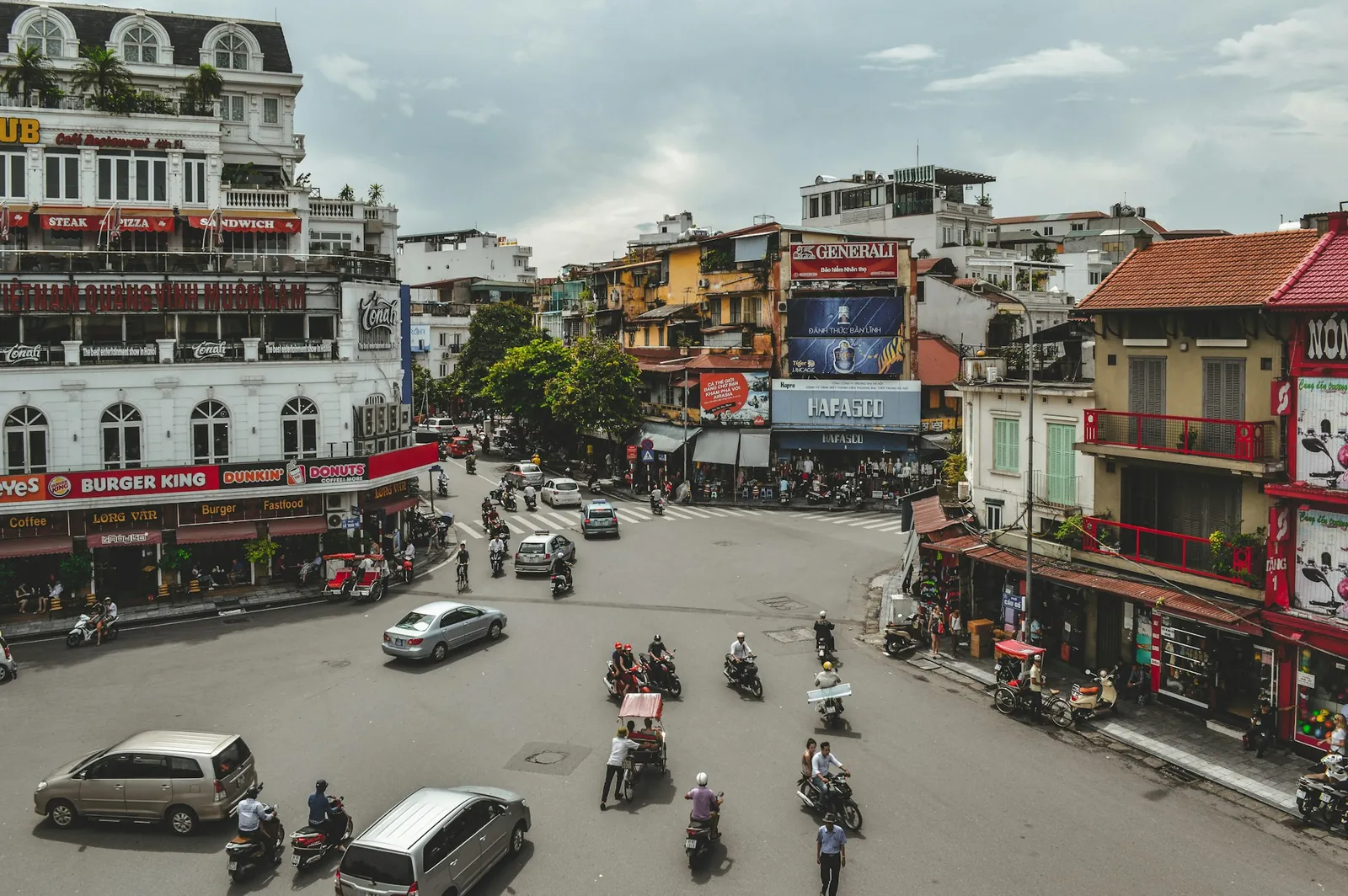 Mopeder, bilar och fotgängare i korsningen vid Hoan Kiem-sjöns norra ände i Hanoi