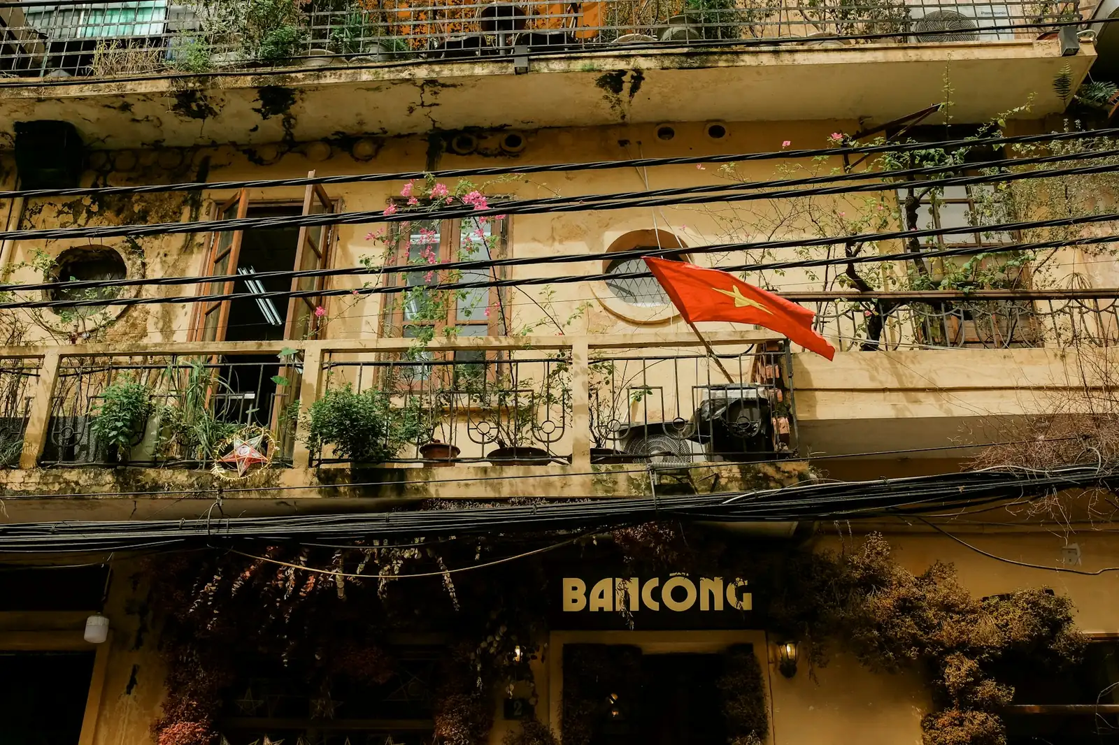 Vietnams röda flagga med gul stjärna på en balkong i Gamla kvarteren i Hanoi